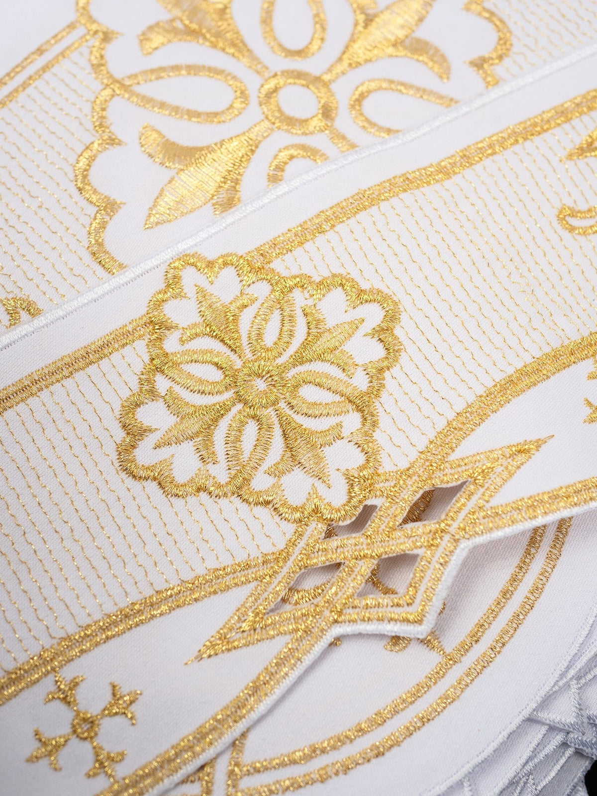 White altar lace close-up showing gold rosette embroidery and geometric border details