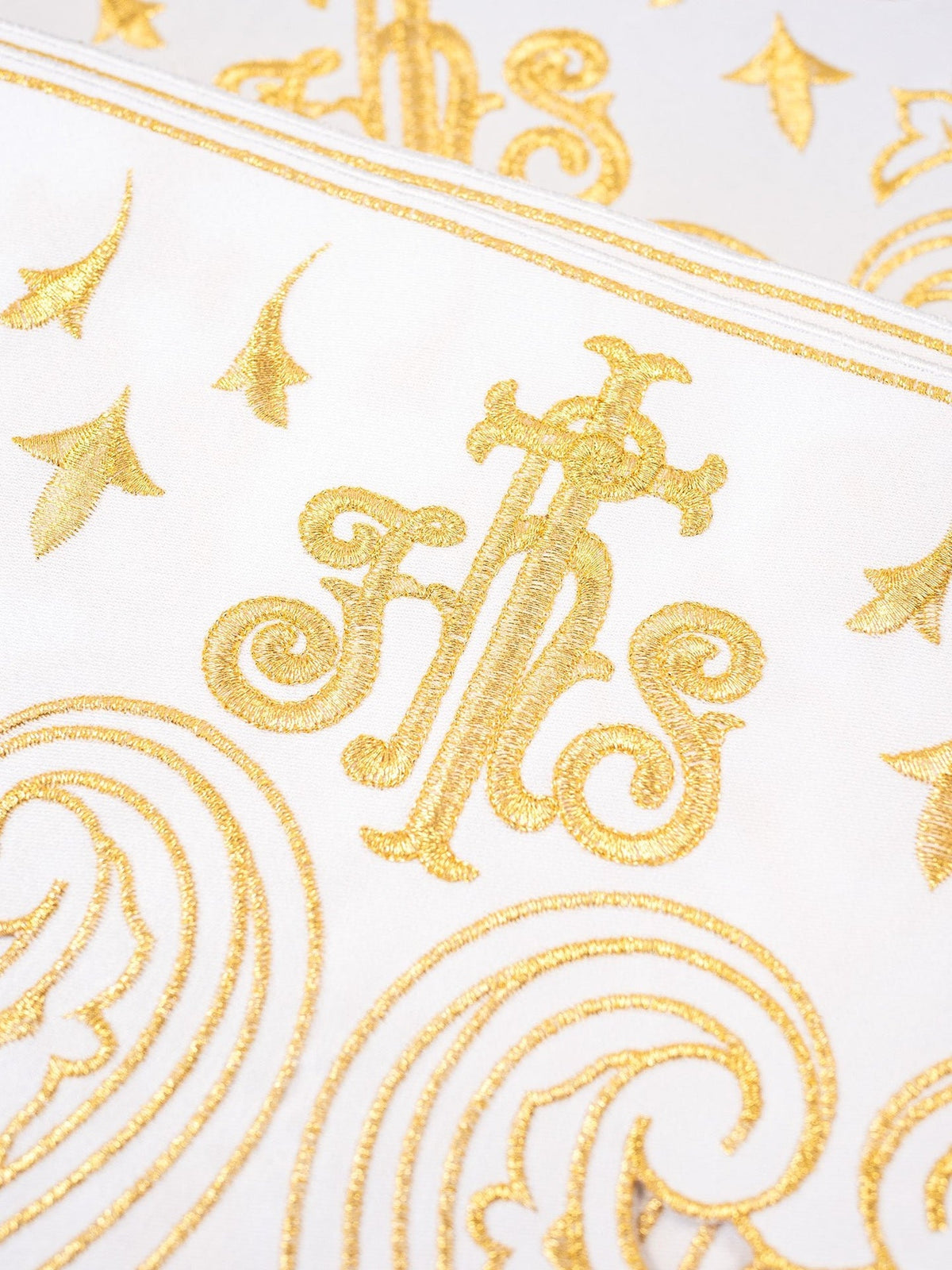 Altar lace close-up showing gold IHS embroidery and ornate white and gold pattern
