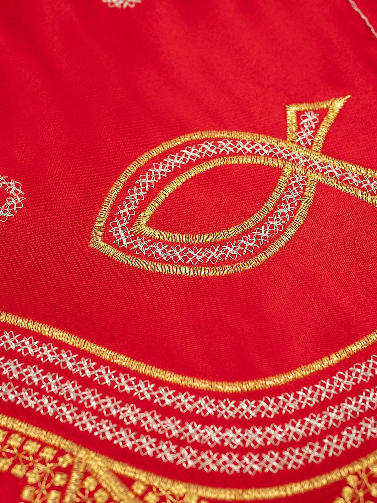 Red altar lace close-up showing fish and wave embroidery in gold and silver