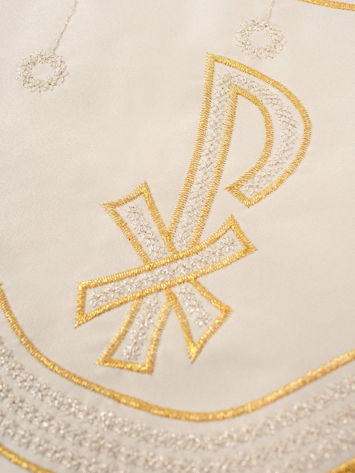 PAX altar lace close-up showing gold and silver embroidery with cross and hanging circular motifs