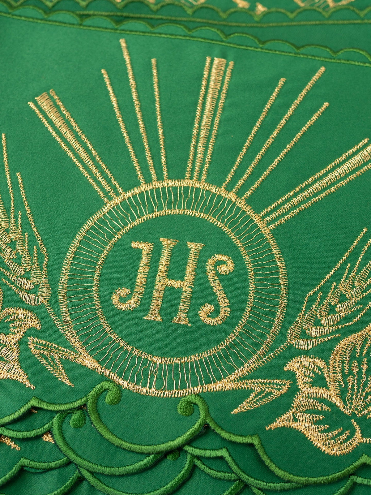 Green altar lace close-up showing gold IHS embroidery, rays, wheat and green scalloped trim