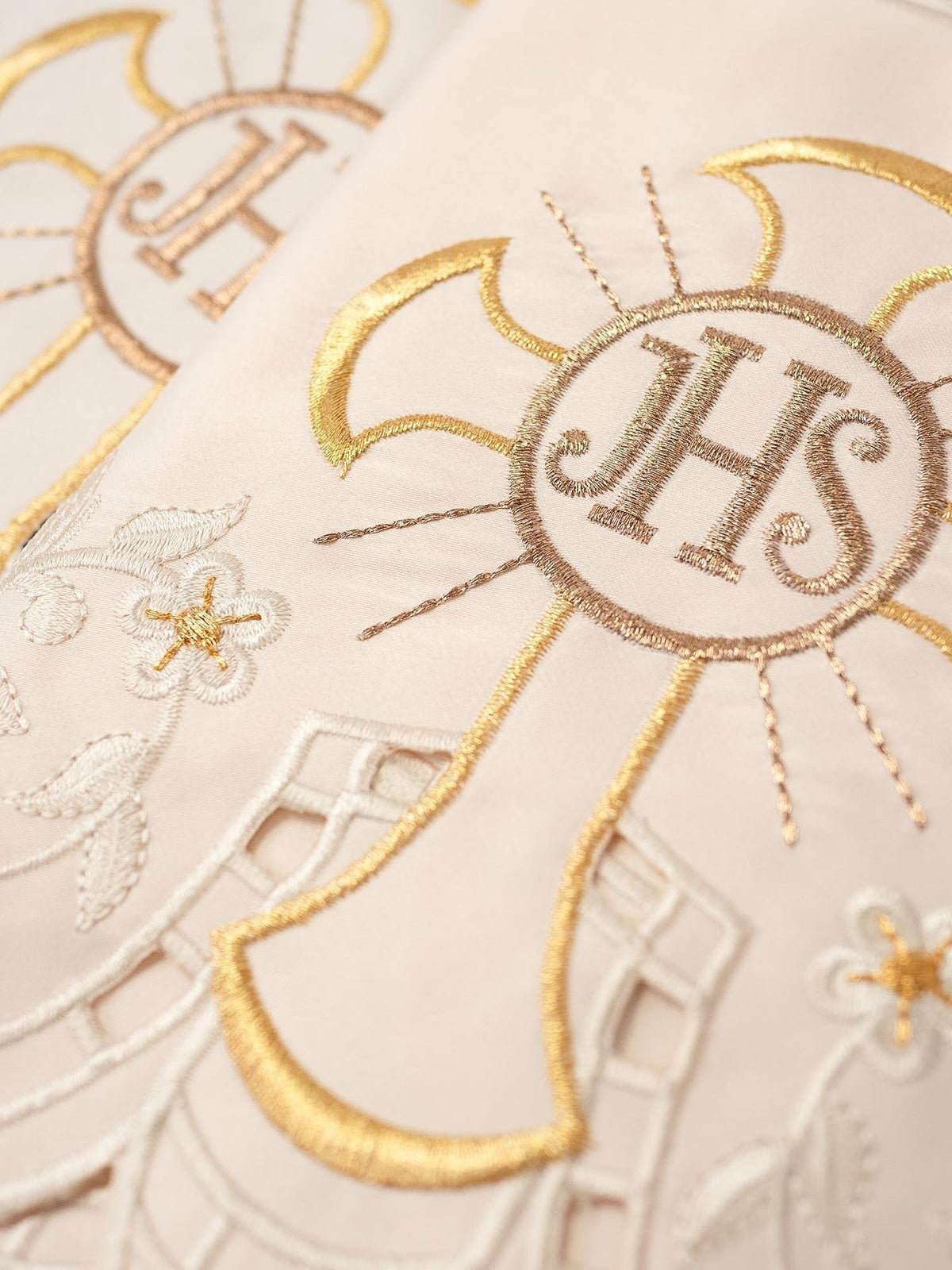 Altar lace close-up showing IHS cross embroidery and floral details
