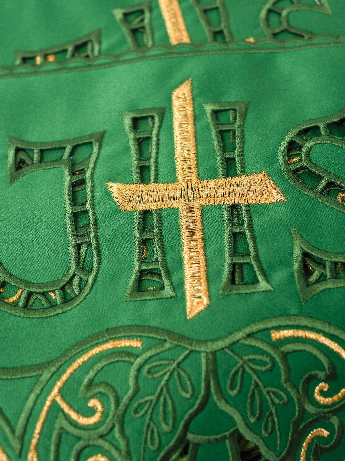 Green altar lace close-up showing gold cross and IHS embroidery