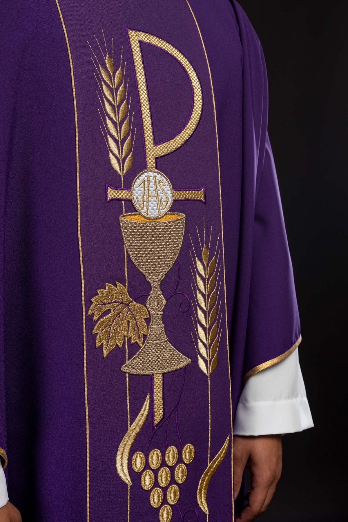 Purple chasuble embroidery close-up with gold chalice, IHS, wheat and grape motifs