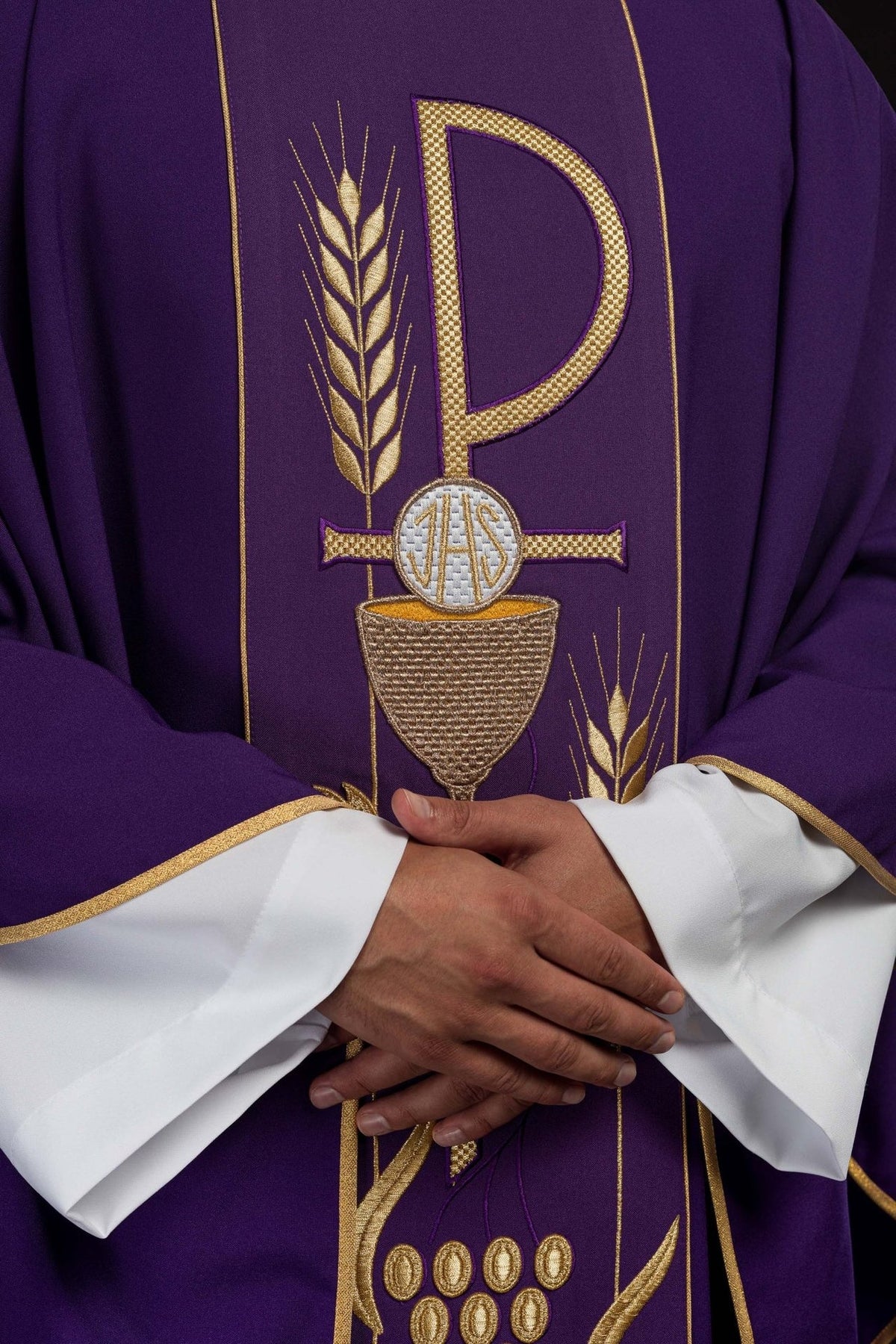 Purple embroidered chasuble front detail showing IHS chalice and gold trim