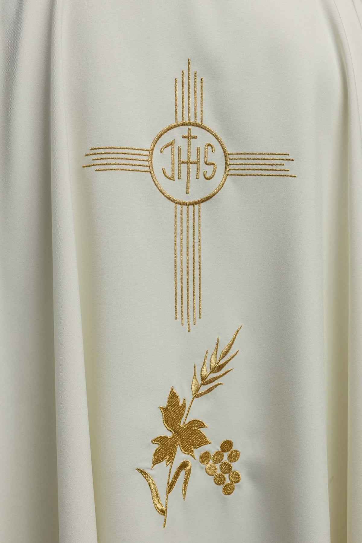 Ecru chasuble close-up showing gold IHS embroidery