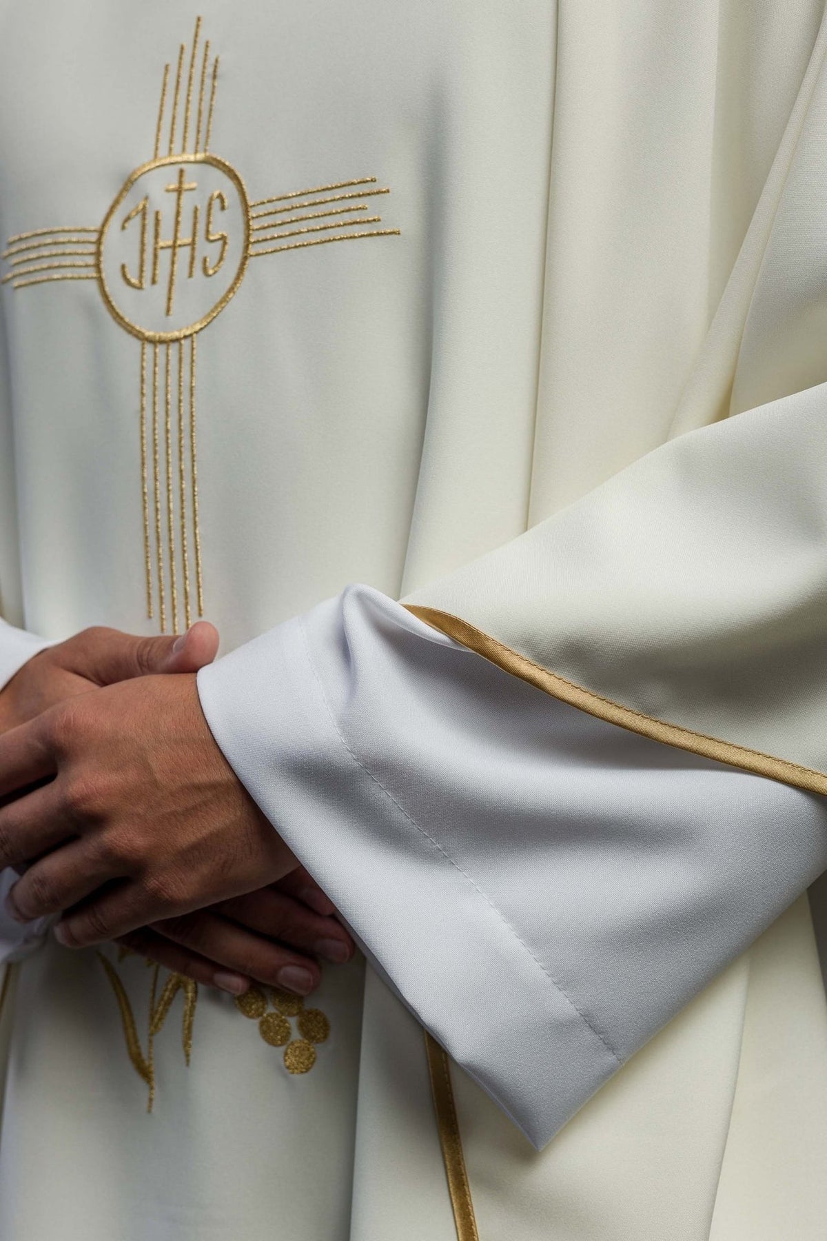 Ecru chasuble detail showing gold IHS and floral embroidery