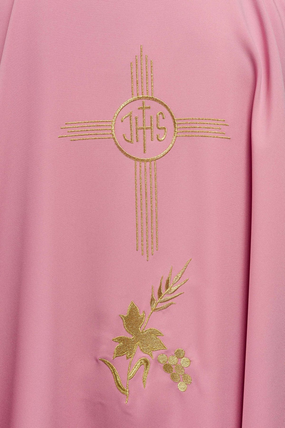 Rose chasuble close-up showing gold IHS embroidery and floral motif