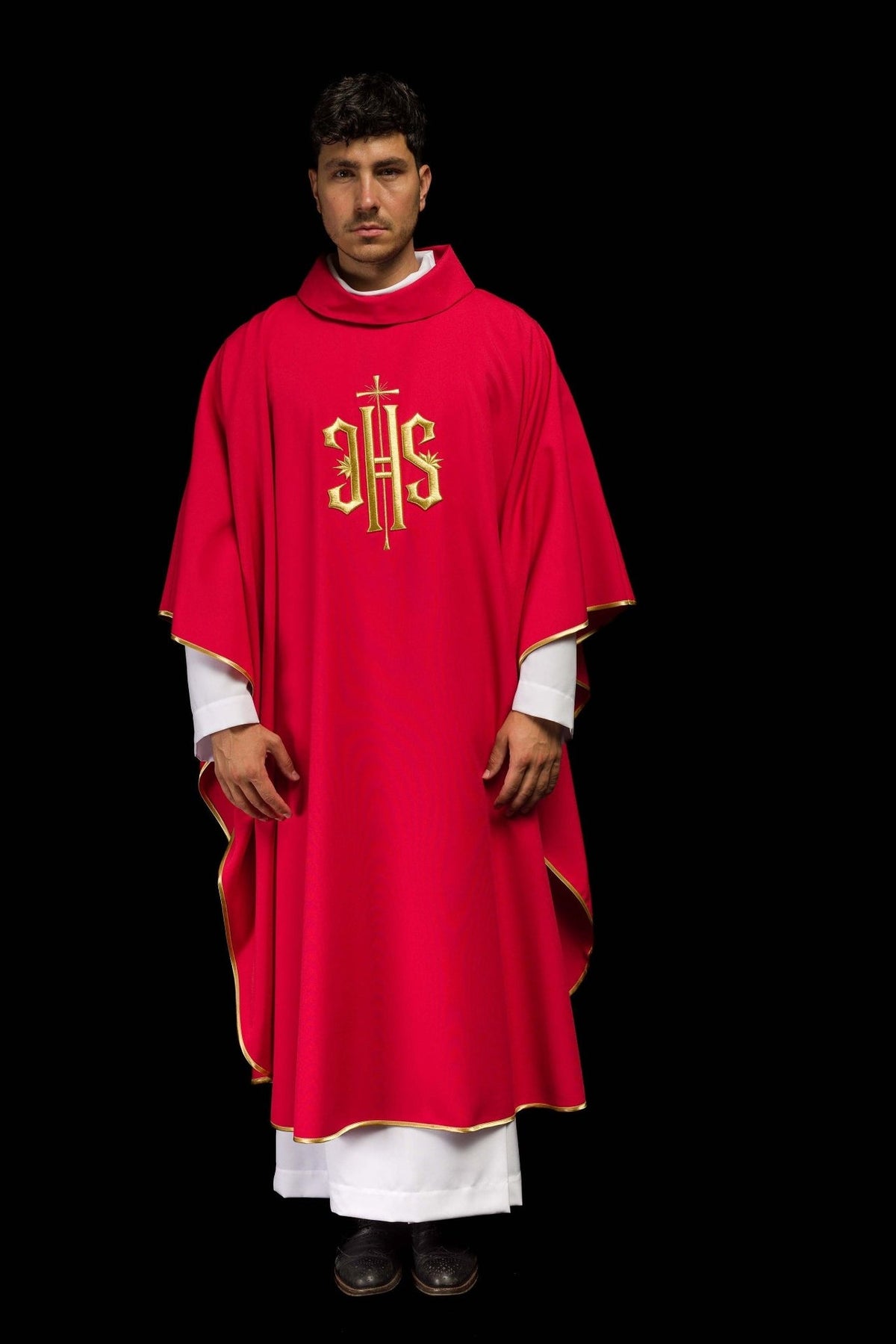 Red chasuble worn in full front view with gold IHS embroidery and trim