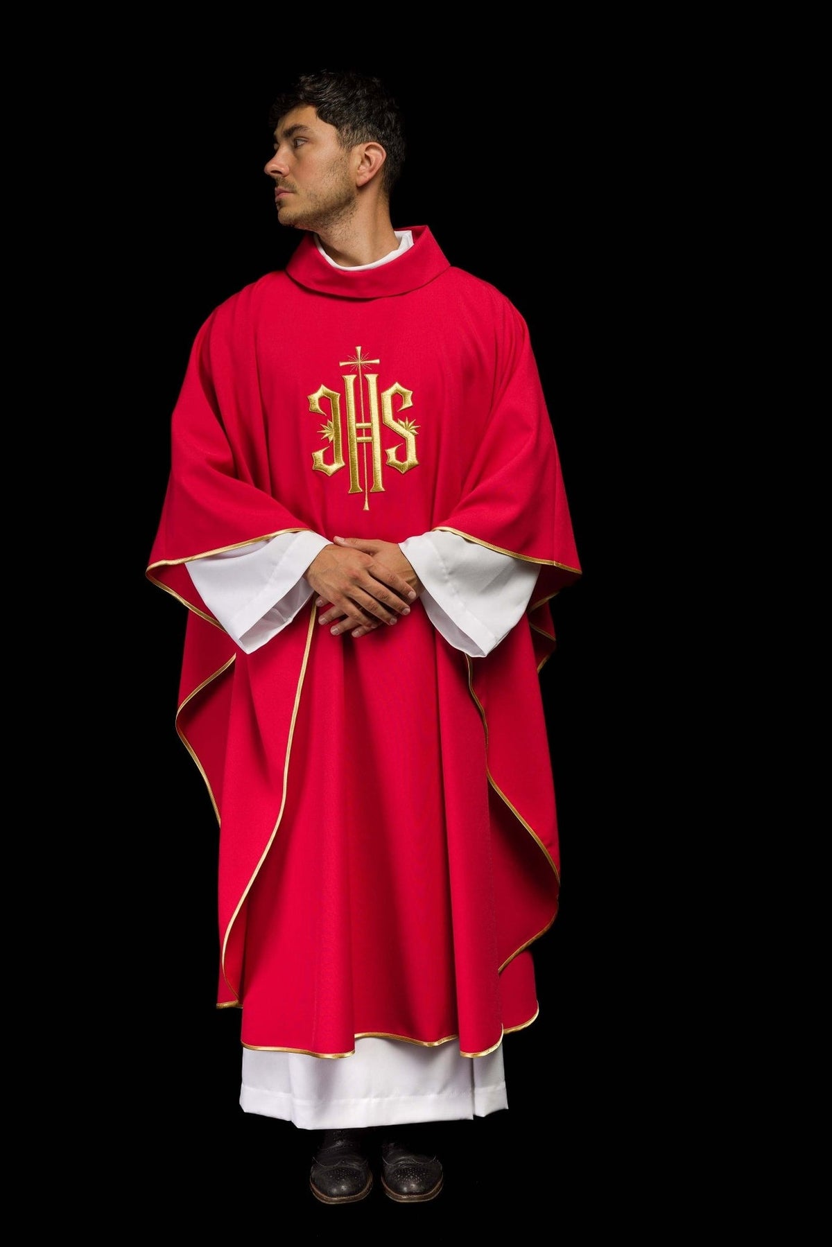 Red chasuble worn at an angle with gold IHS embroidery and satin trim