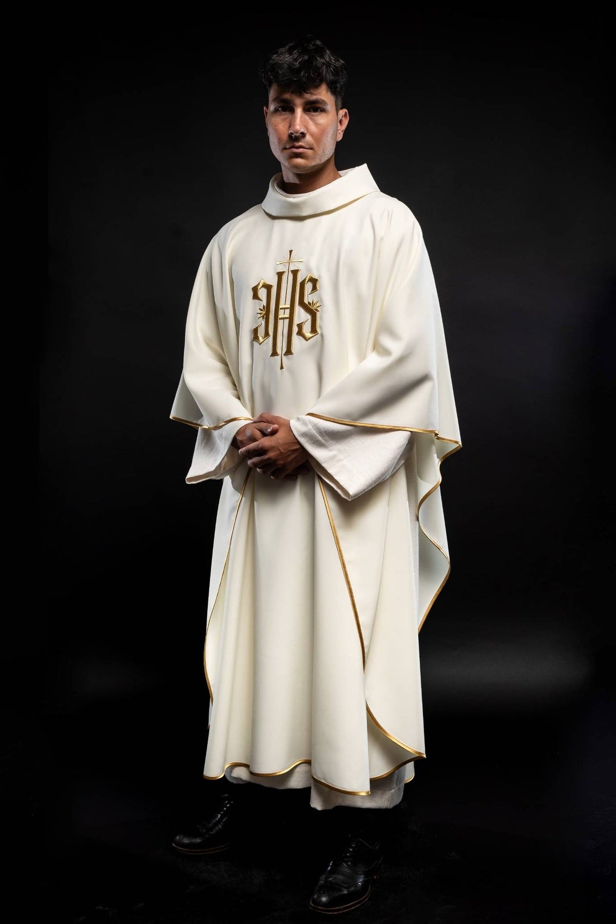 Ecru chasuble worn full length, showing gold IHS embroidery and gold trim