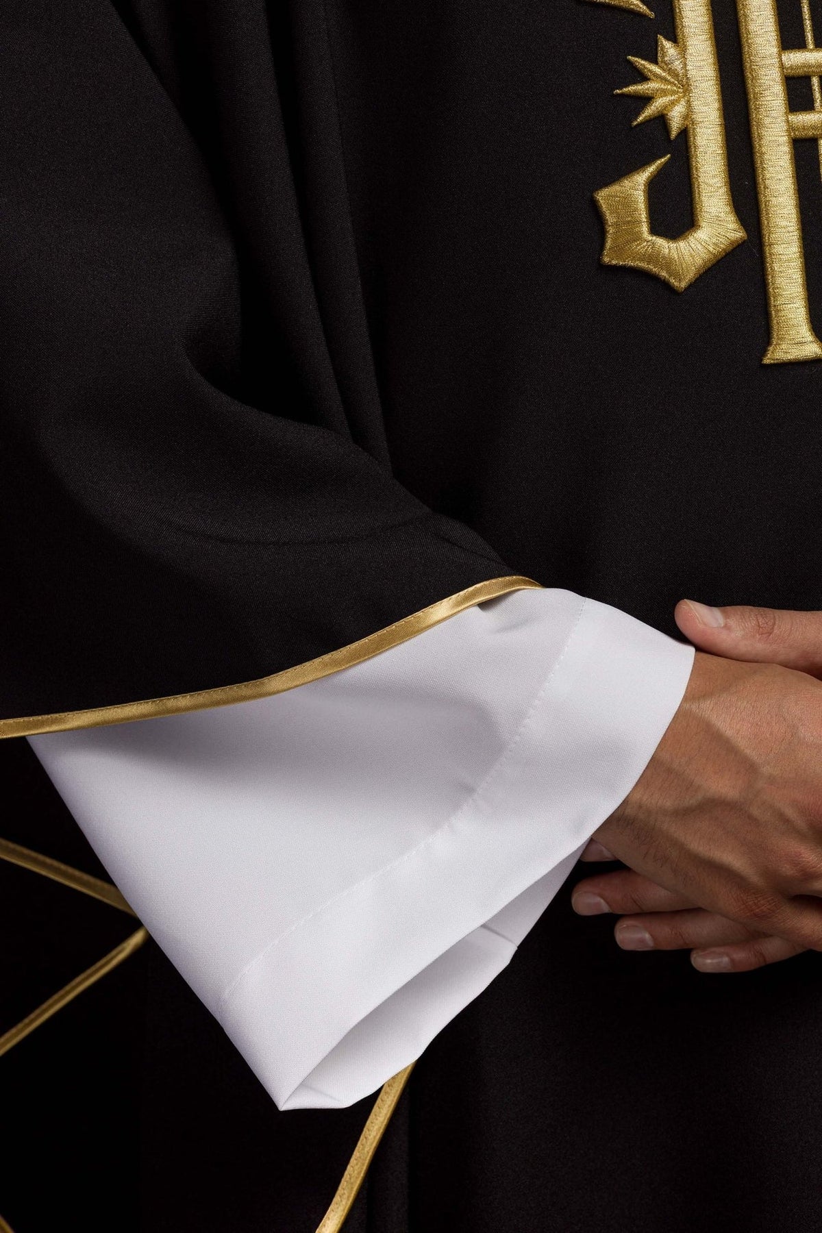 Black chasuble detail showing satin sleeve and gold trim
