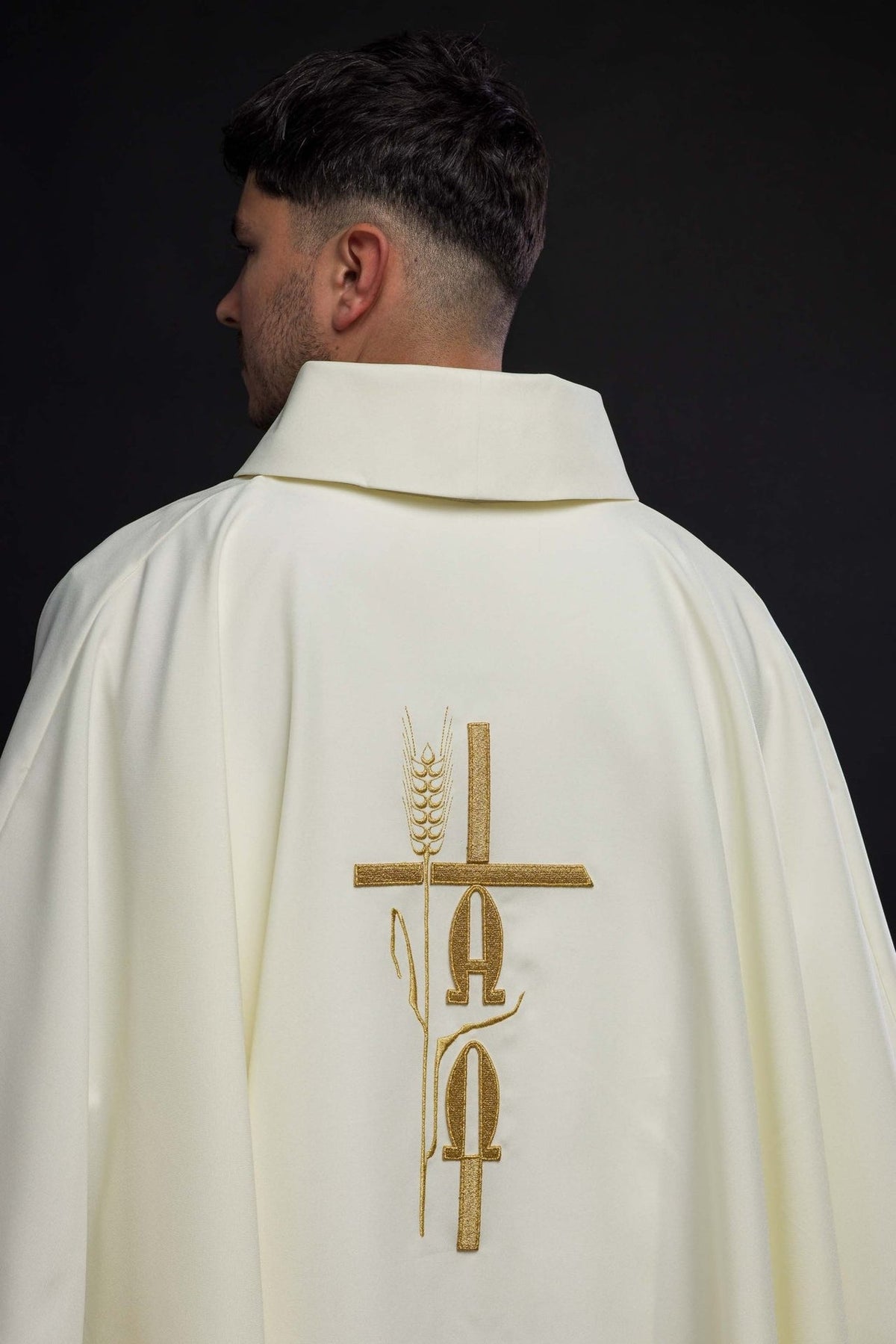 Ecru chasuble back view showing gold Alpha, Omega and cross embroidery
