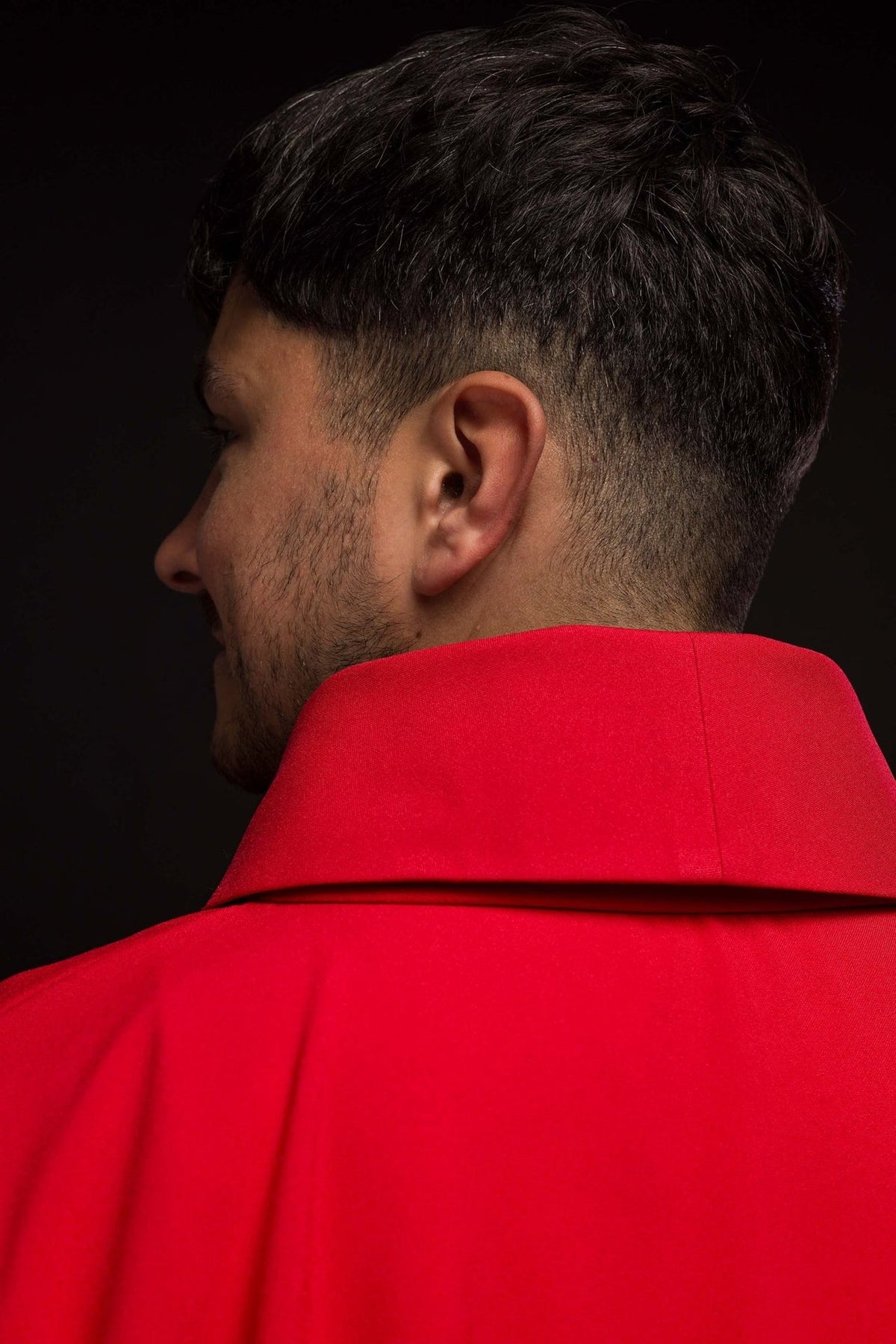 Red chasuble close-up showing polyester fabric and inner label