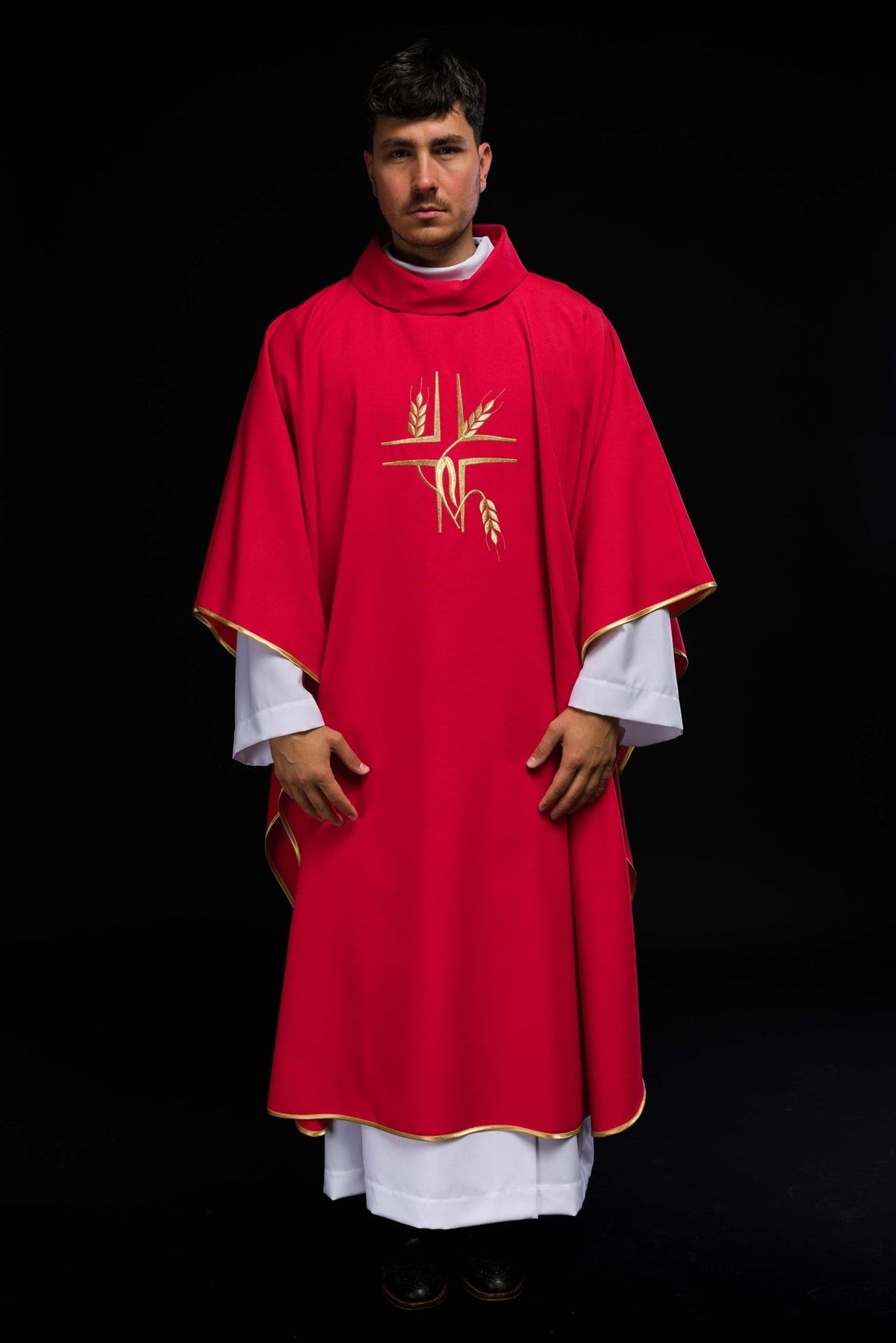 Red chasuble worn front view with gold trim and embroidery