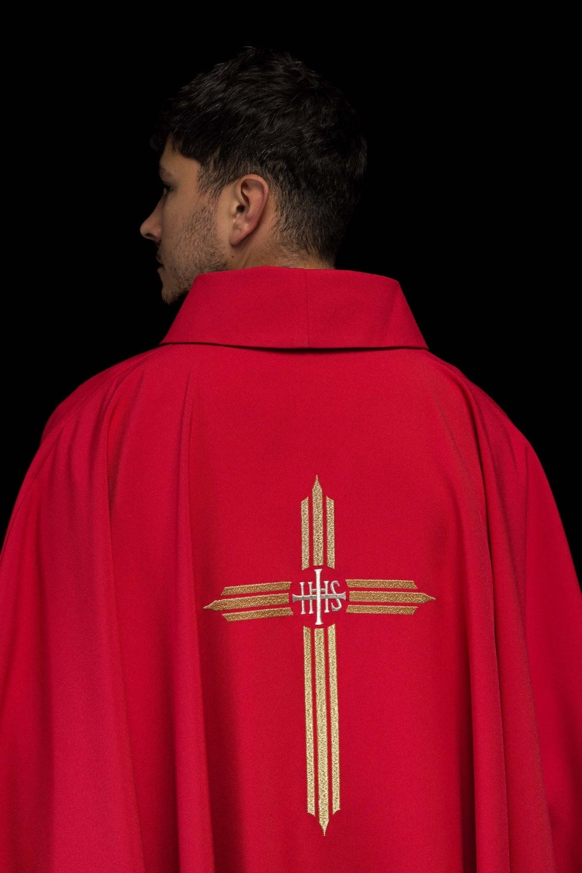 Red chasuble close-up showing the stand-up collar and partial cross embroidery