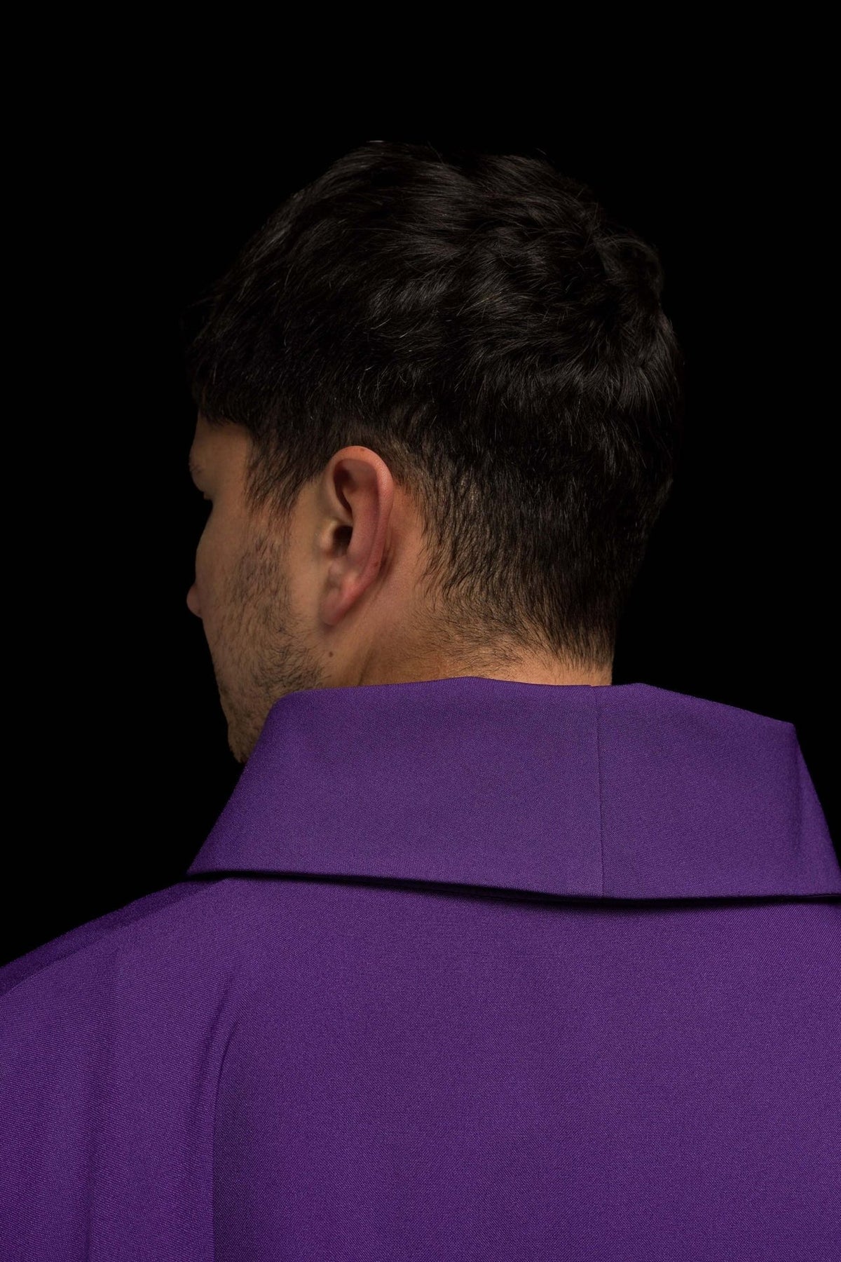 Purple chasuble close-up showing gold trim and fabric folds