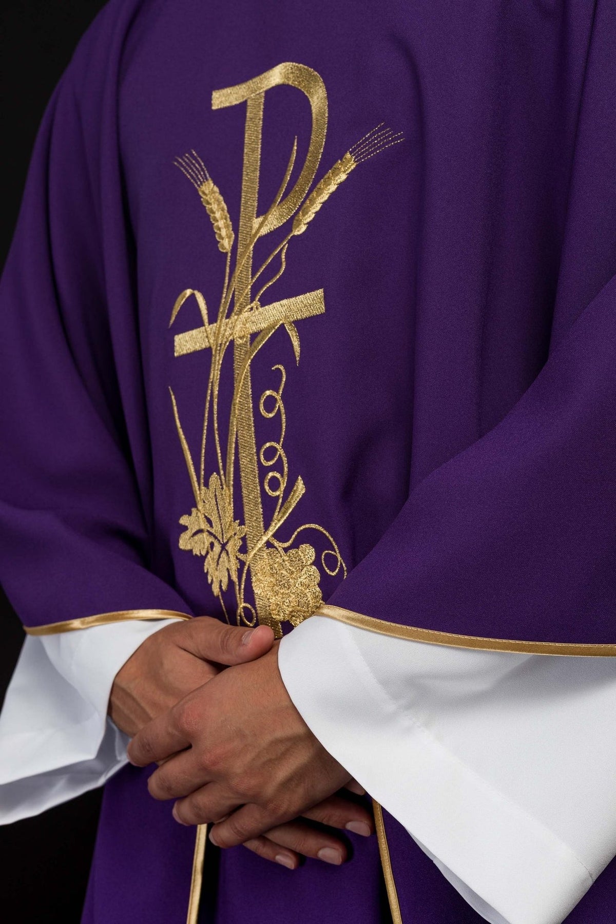 Purple chasuble front detail with gold PAX embroidery and satin trim