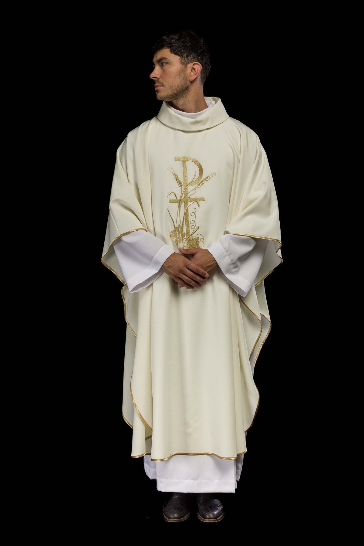 Ecru chasuble worn full length from the front, with gold trim and central embroidery