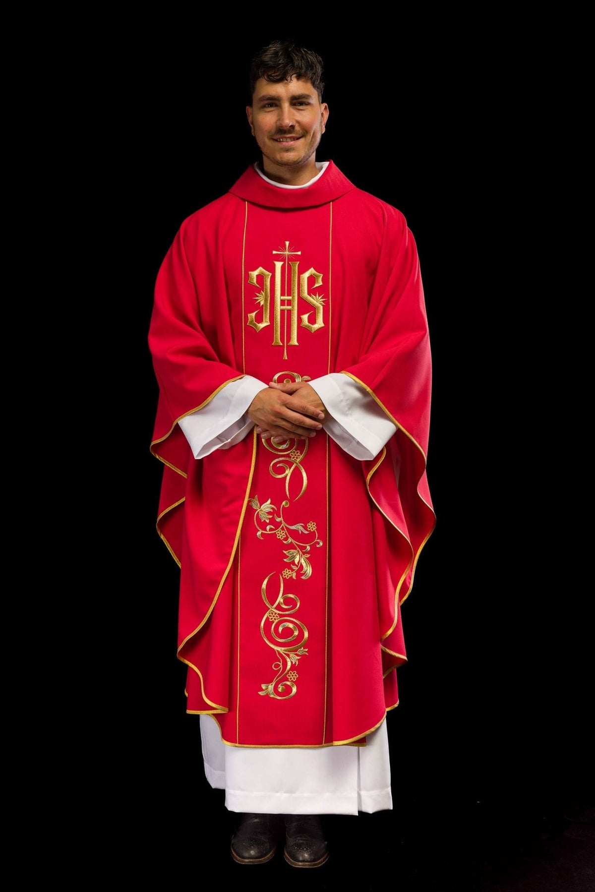 Red chasuble worn front view with gold IHS and floral embroidery