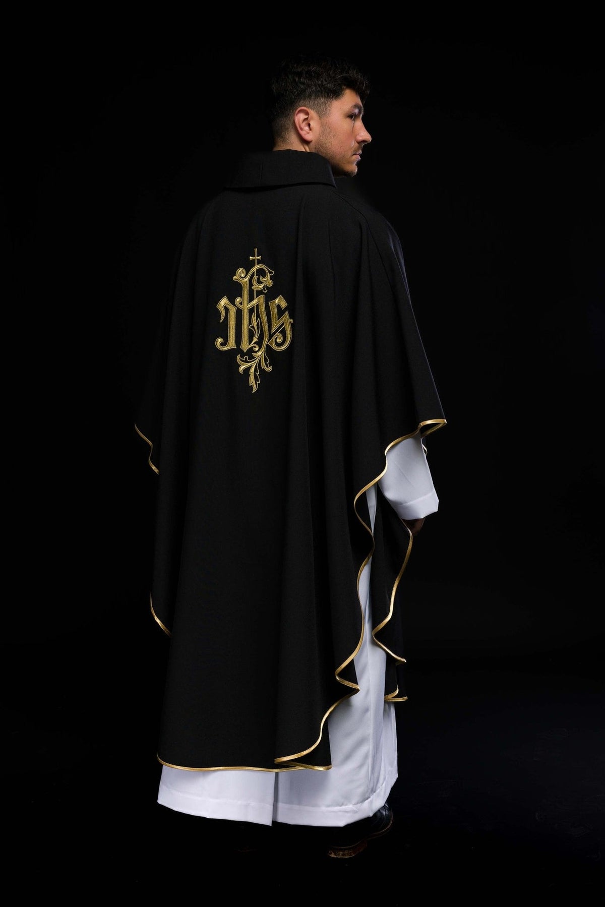 Black IHS chasuble worn back view with gold embroidery