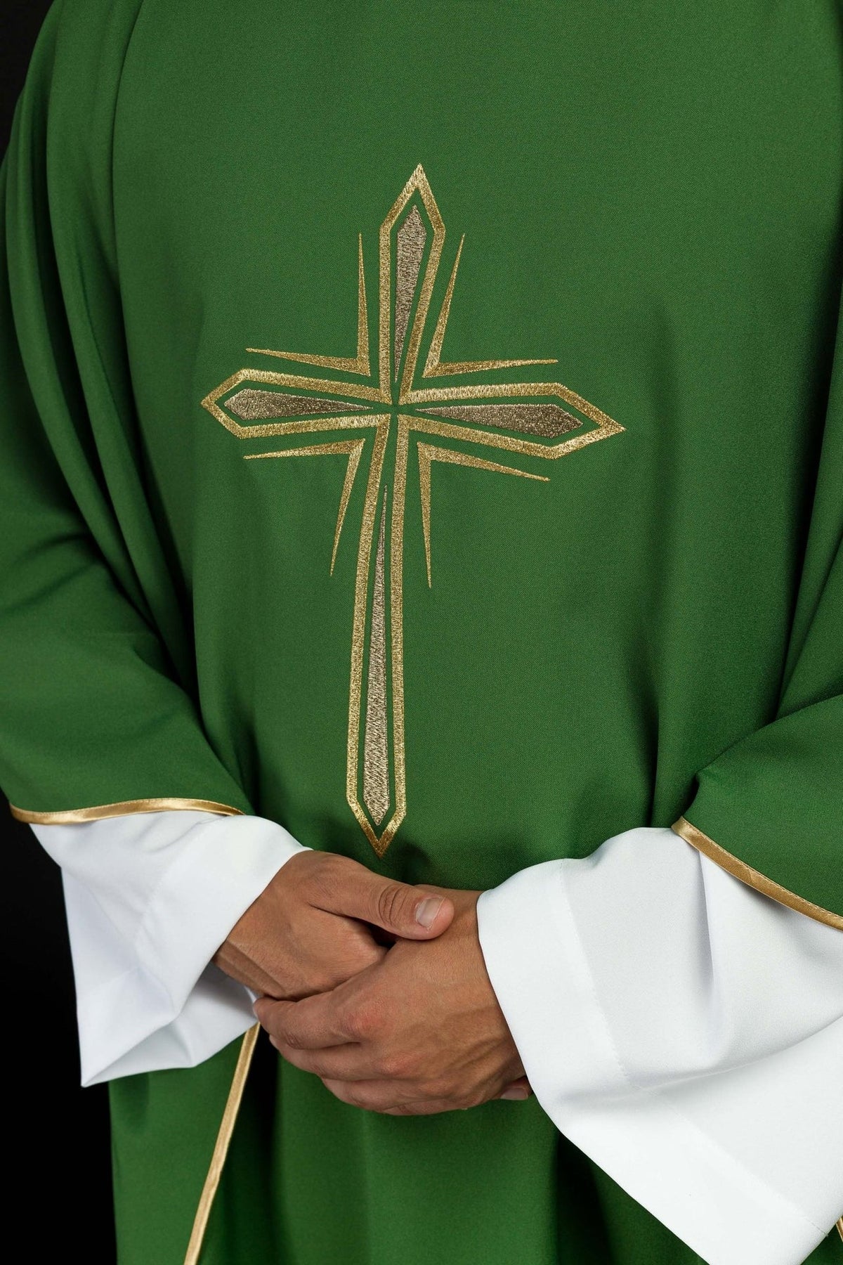 Green chasuble close-up showing gold embroidered cross and gold trim