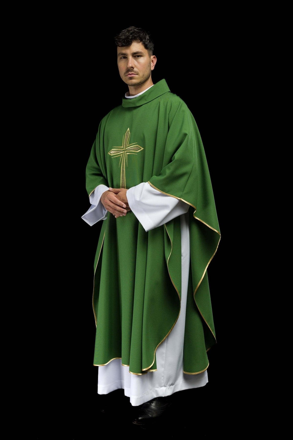 Green chasuble three-quarter view showing flowing shape, gold trim and front cross