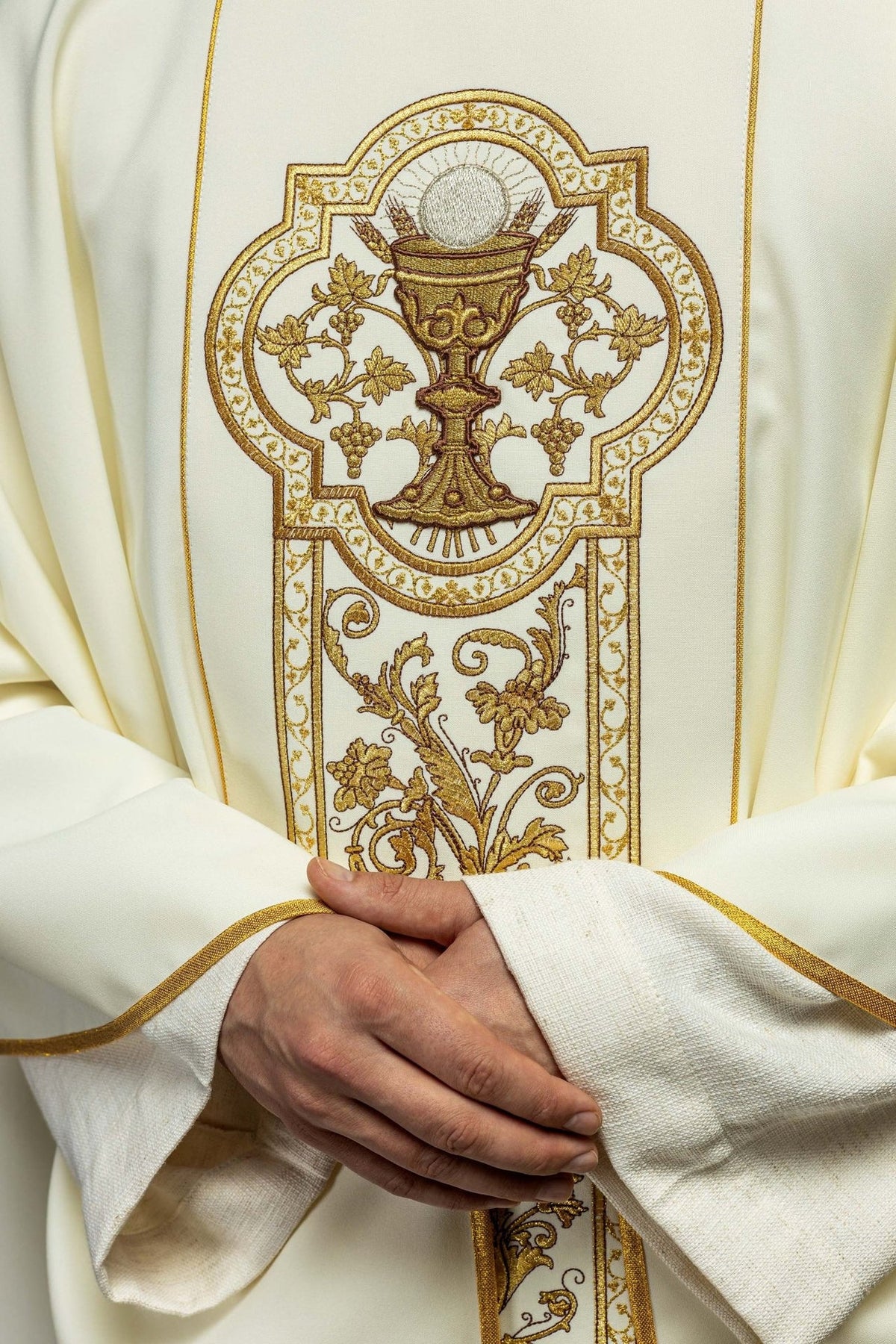 Ecru chasuble close-up of communion chalice embroidery and gold floral orphrey