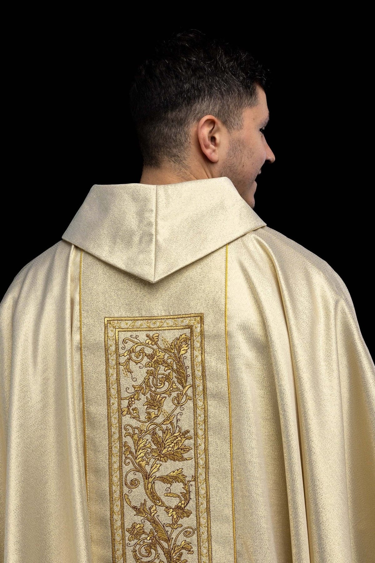 Gold chasuble back view with long floral embroidered orphrey
