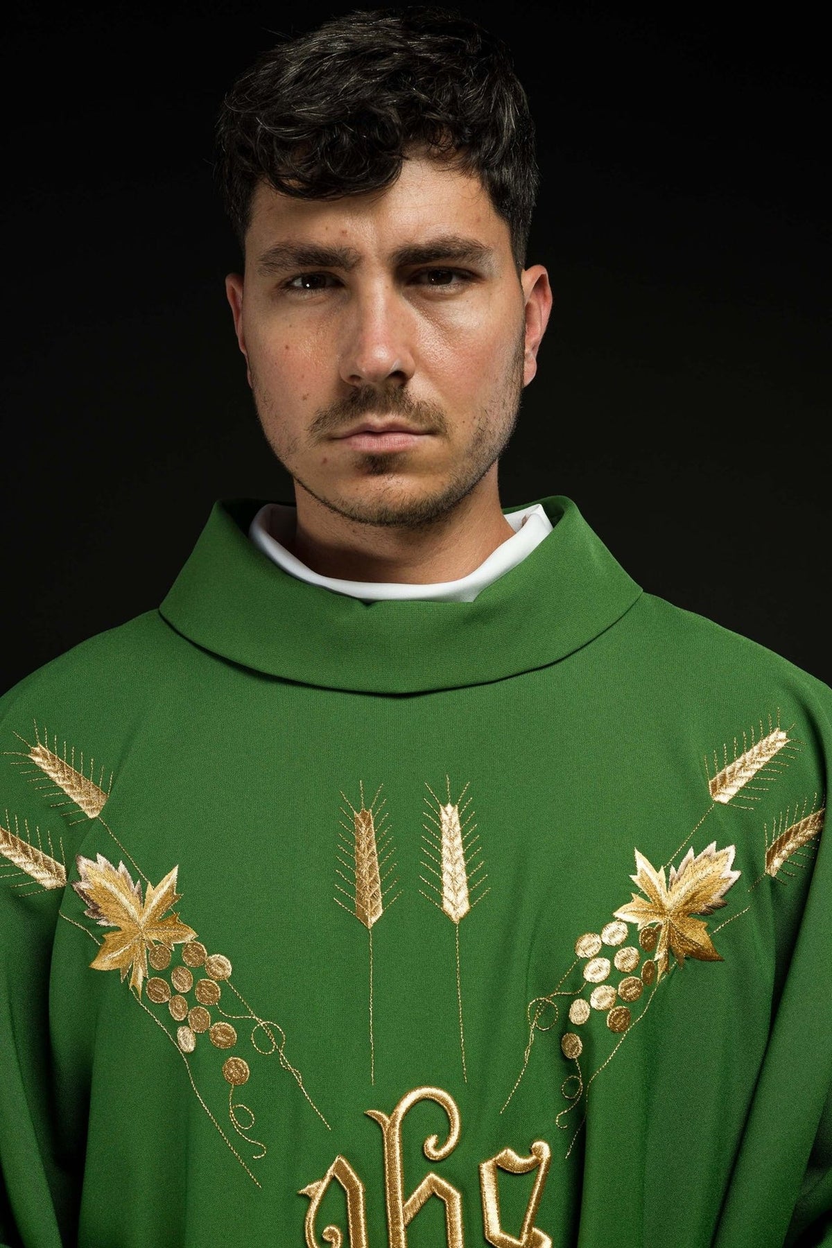 Green chasuble close-up showing stand-up collar and gold embroidered grapes