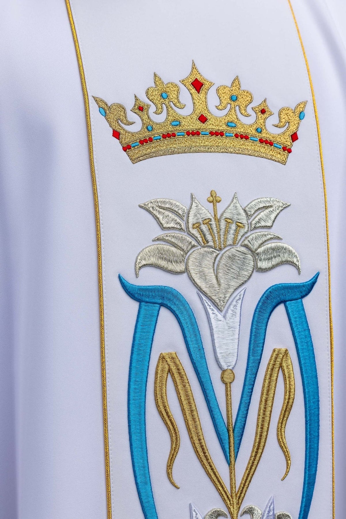 Marian chasuble close-up showing embroidered gold crown and Marian monogram