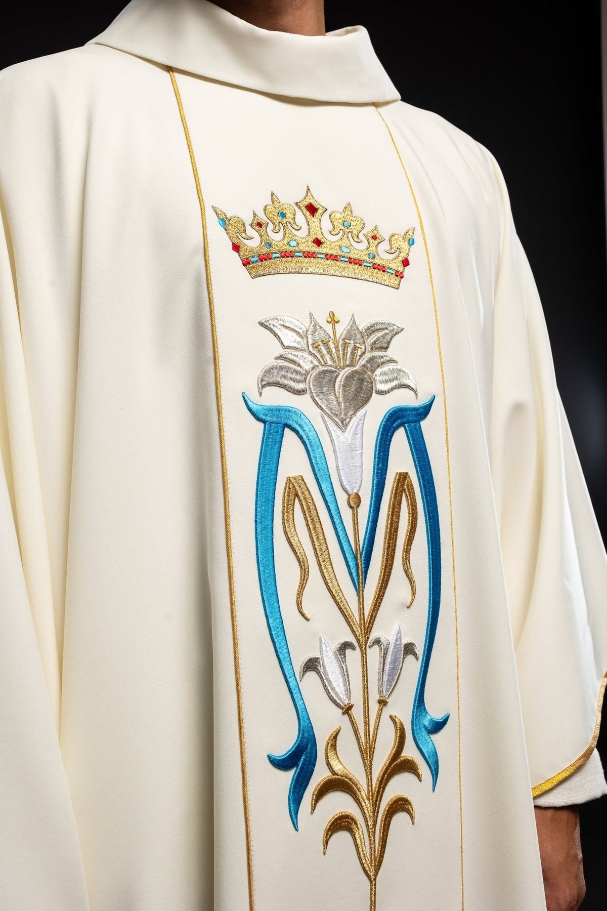 Ecru Marian chasuble close-up showing embroidered gold crown and Marian motif