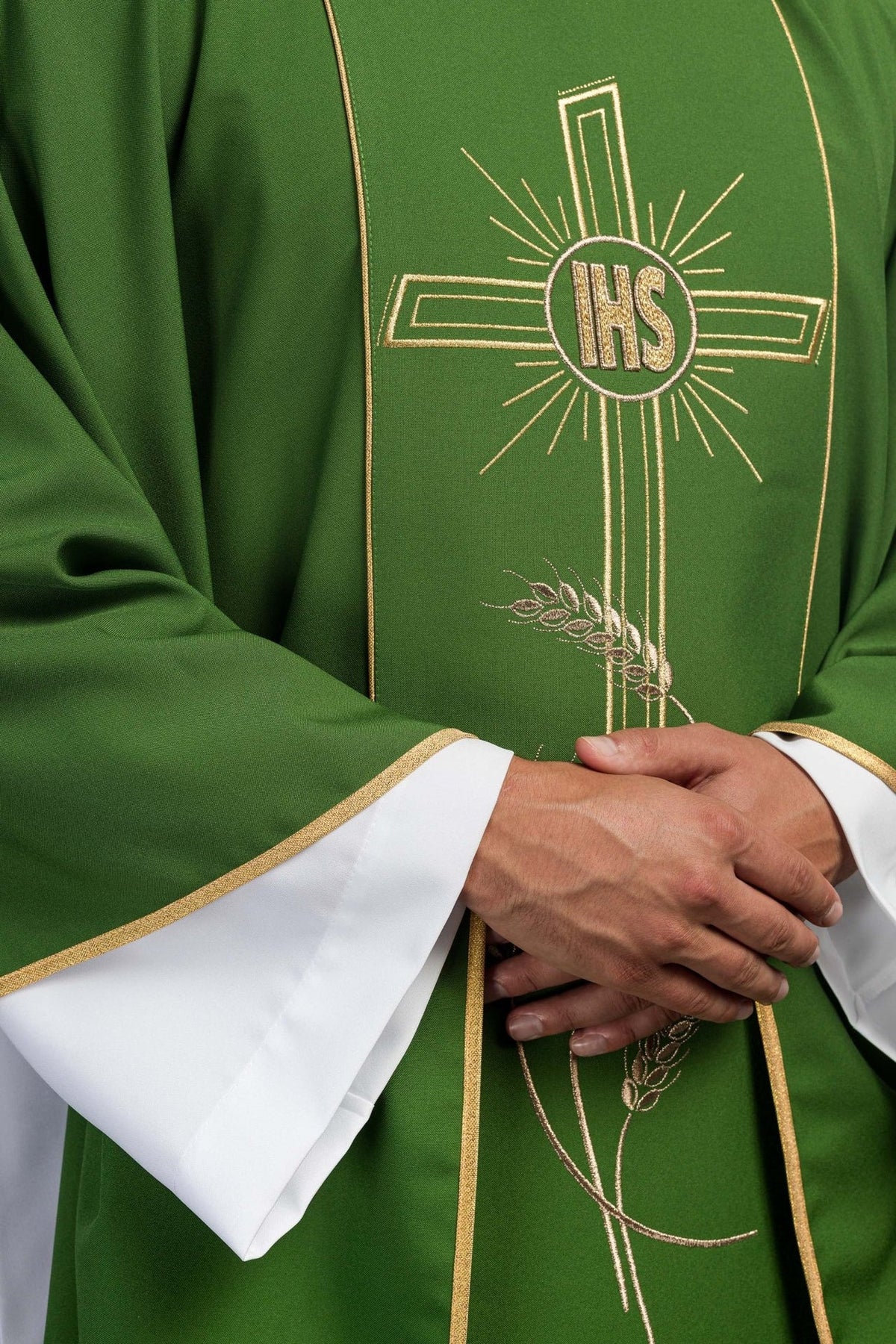 Green chasuble close-up showing gold IHS cross, orphrey and trim