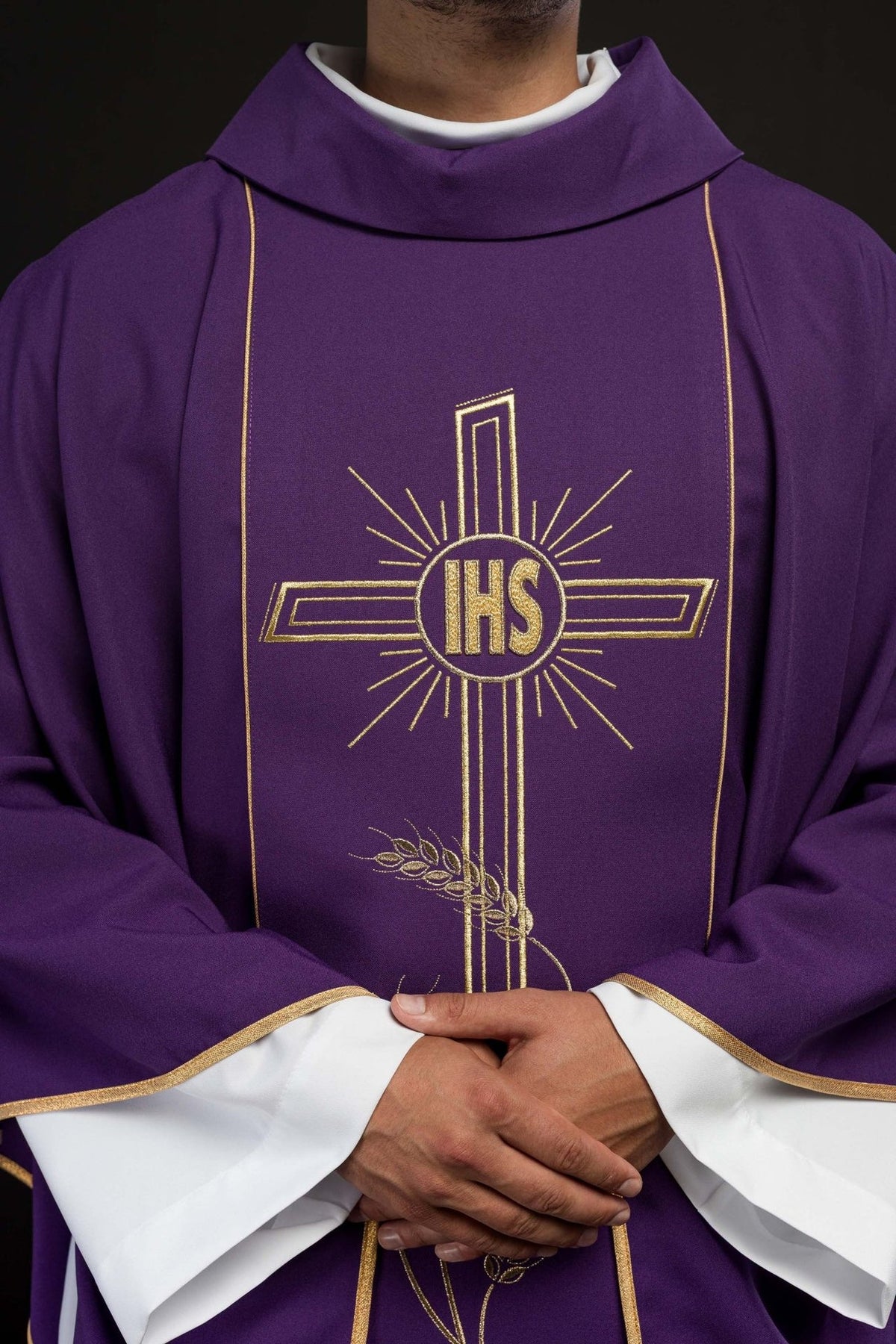 Purple chasuble close-up showing embroidered gold IHS cross and stand-up collar