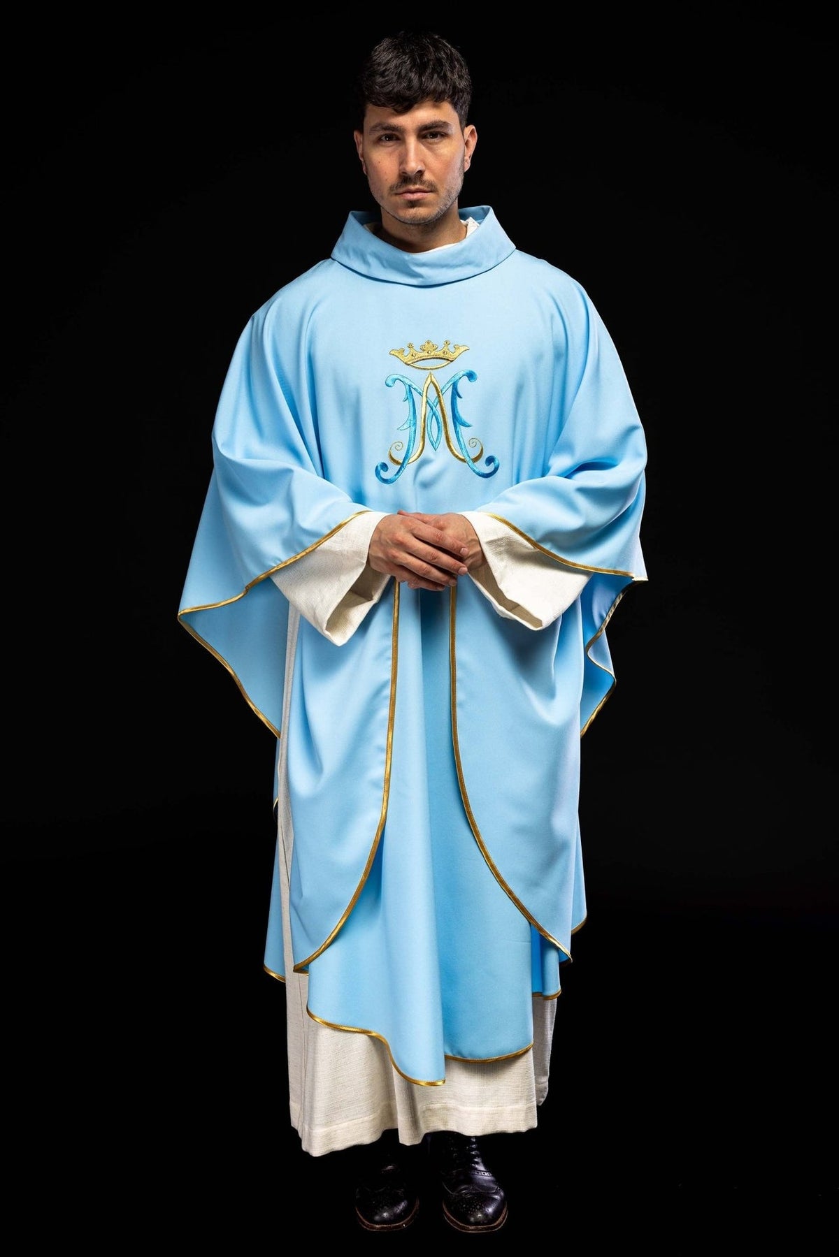 Blue chasuble worn front view with gold trim and embroidered Marian motif