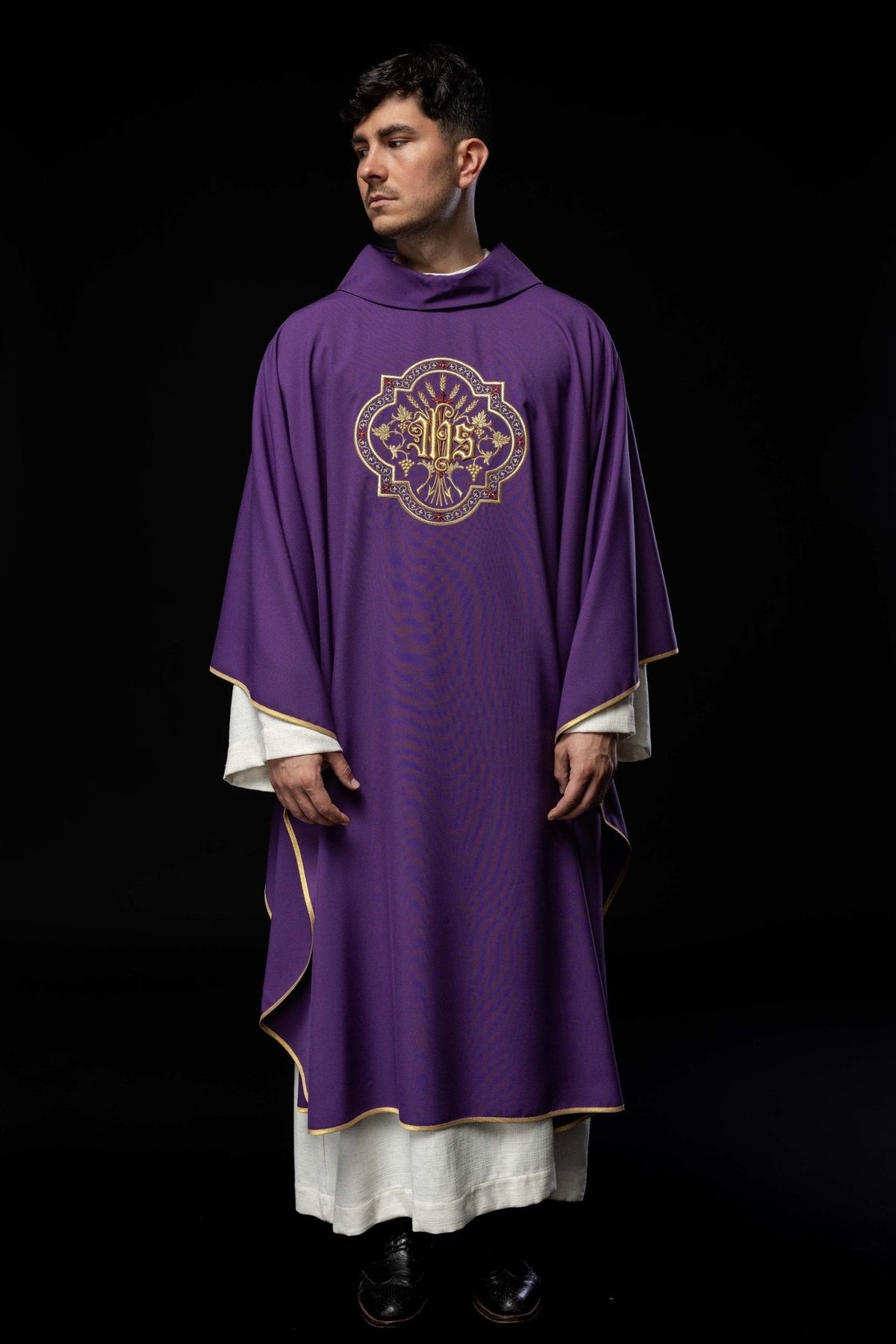Purple chasuble worn in a full front view with gold trim and IHS embroidery