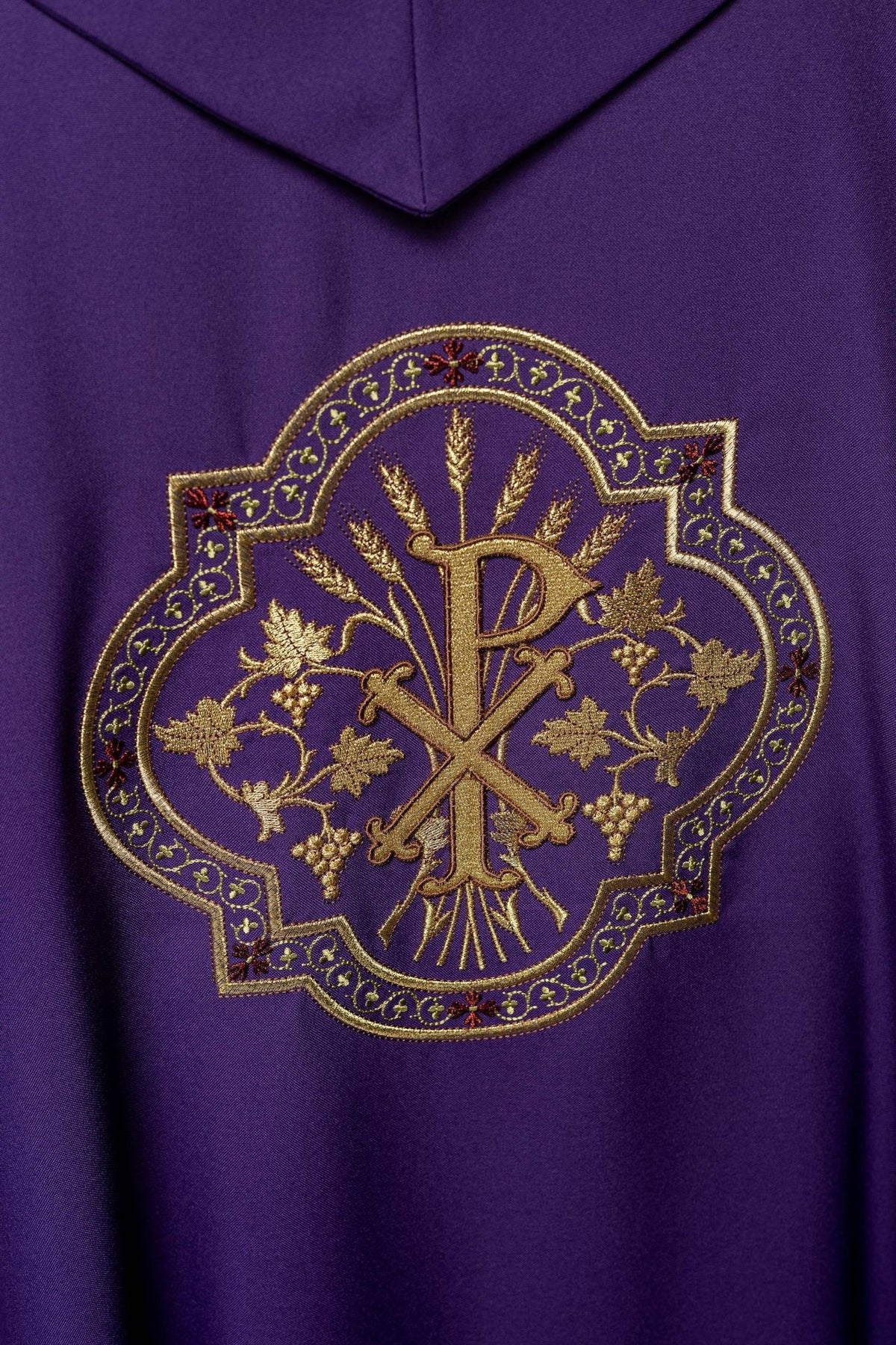 Purple chasuble back close-up with gold PAX embroidery, grapes and wheat
