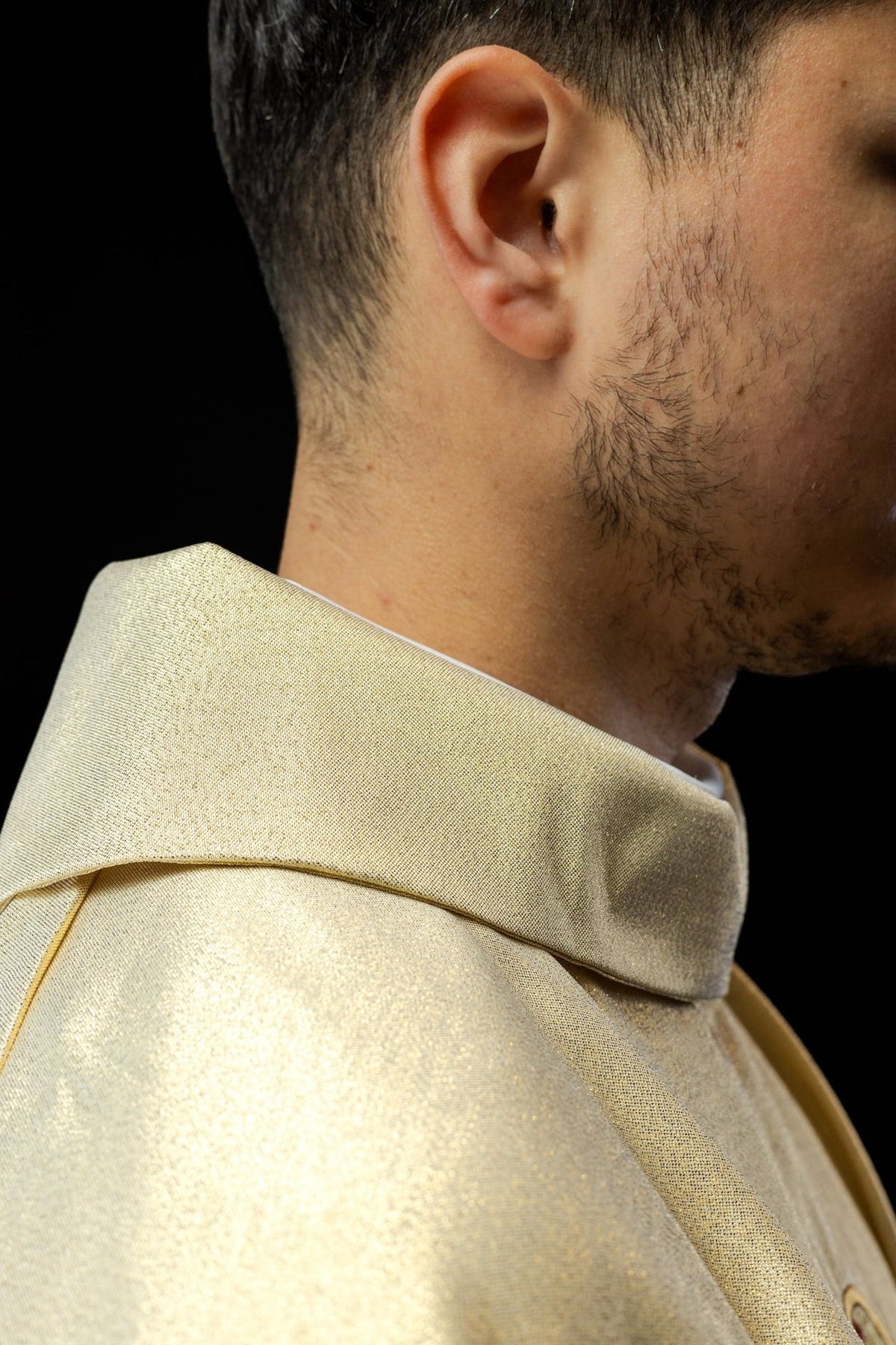 Gold chasuble close-up showing the gold stand-up collar and satin-like fabric