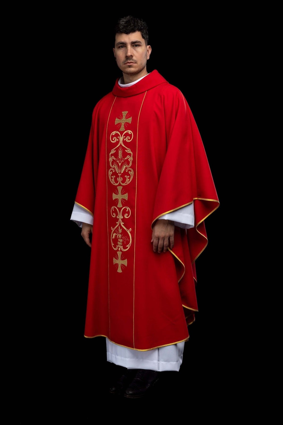Red chasuble, side view showing flowing sleeves, gold trim and front orphrey