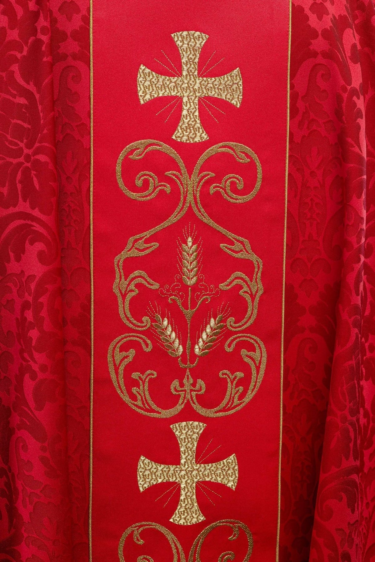 Red chasuble embroidered orphrey close-up with gold cross, scrollwork and wheat motifs