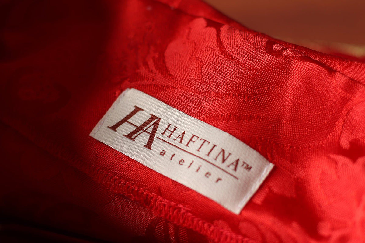 Red chasuble interior close-up showing jacquard fabric and sewn label