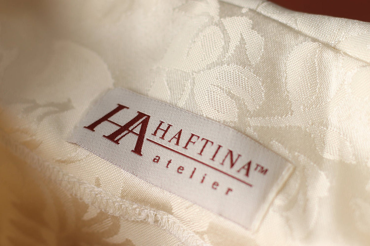Liturgical chasuble close-up showing ivory stand-up collar, jacquard fabric and gold trim