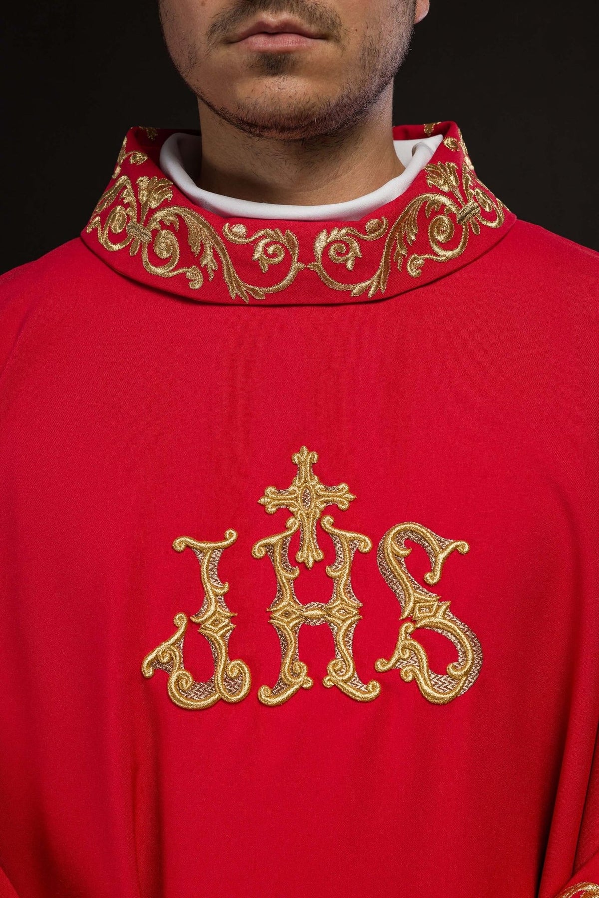 Red chasuble close-up showing gold stand-up collar embroidery and IHS embroidery