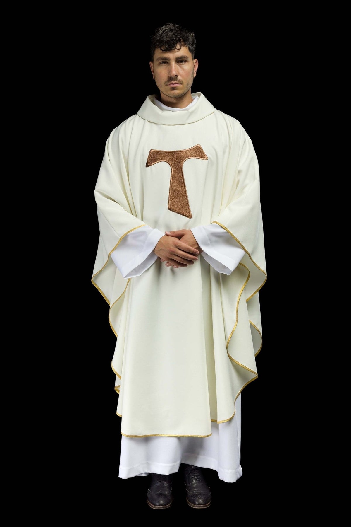 White chasuble front detail showing the TAU cross and gold sleeve trim