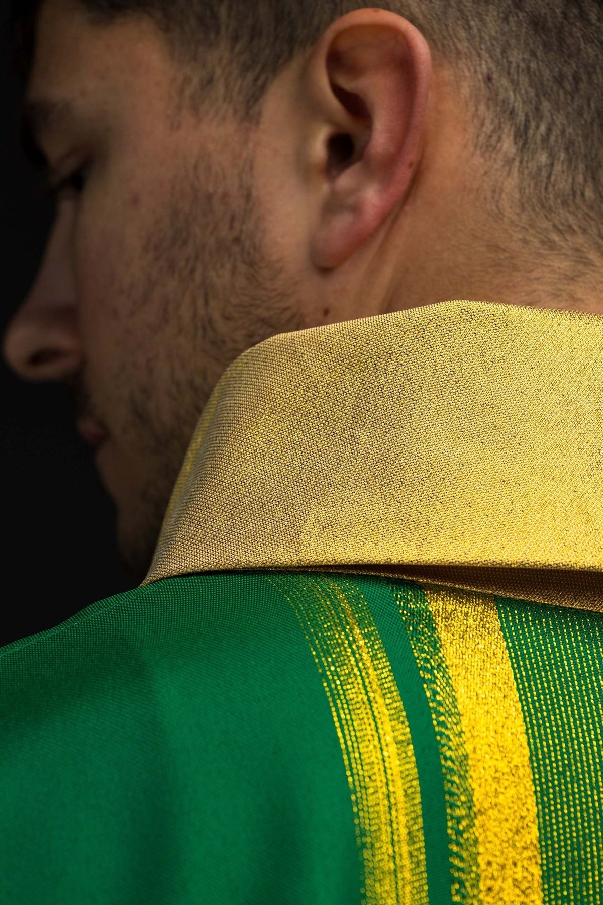 Green chasuble close-up showing gold sleeve trim