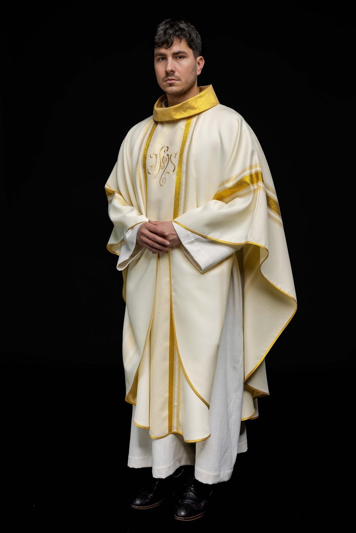 Chasuble angled front view showing gold trim, IHS embroidery and sleeve bands