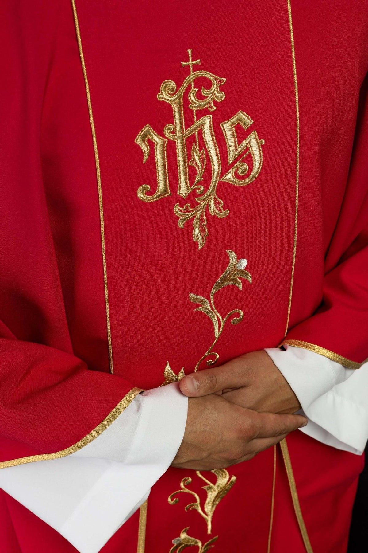 Red chasuble close-up showing gold embroidered floral orphrey