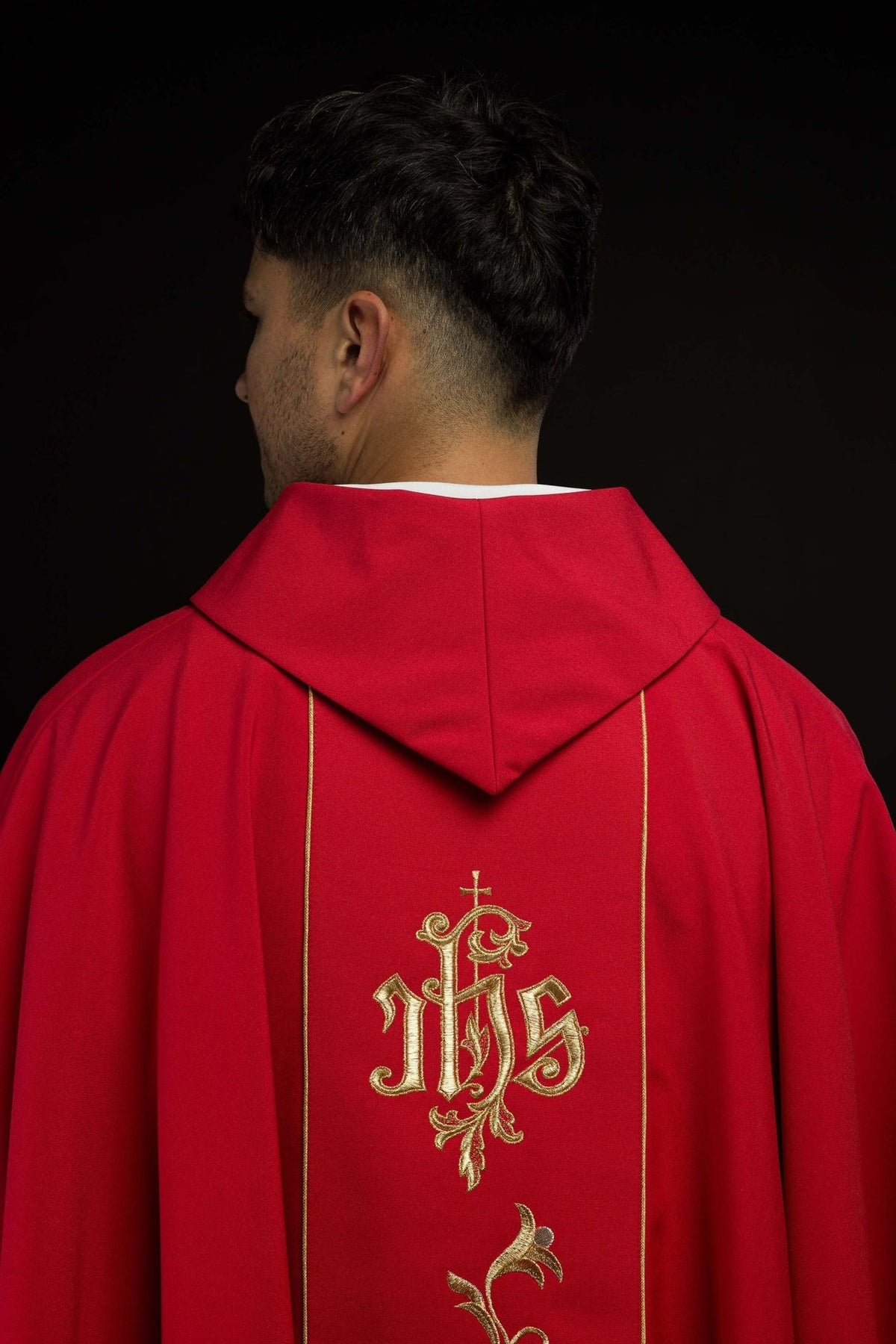 Red chasuble back view showing embroidered IHS orphrey and floral design