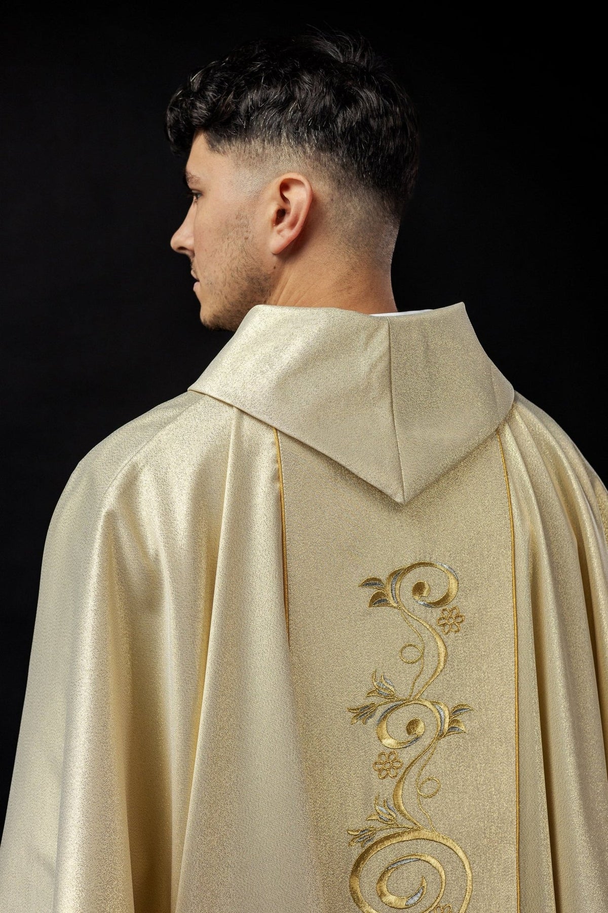 Gold chasuble detail showing embroidered Holy Family, gold edging and scrollwork