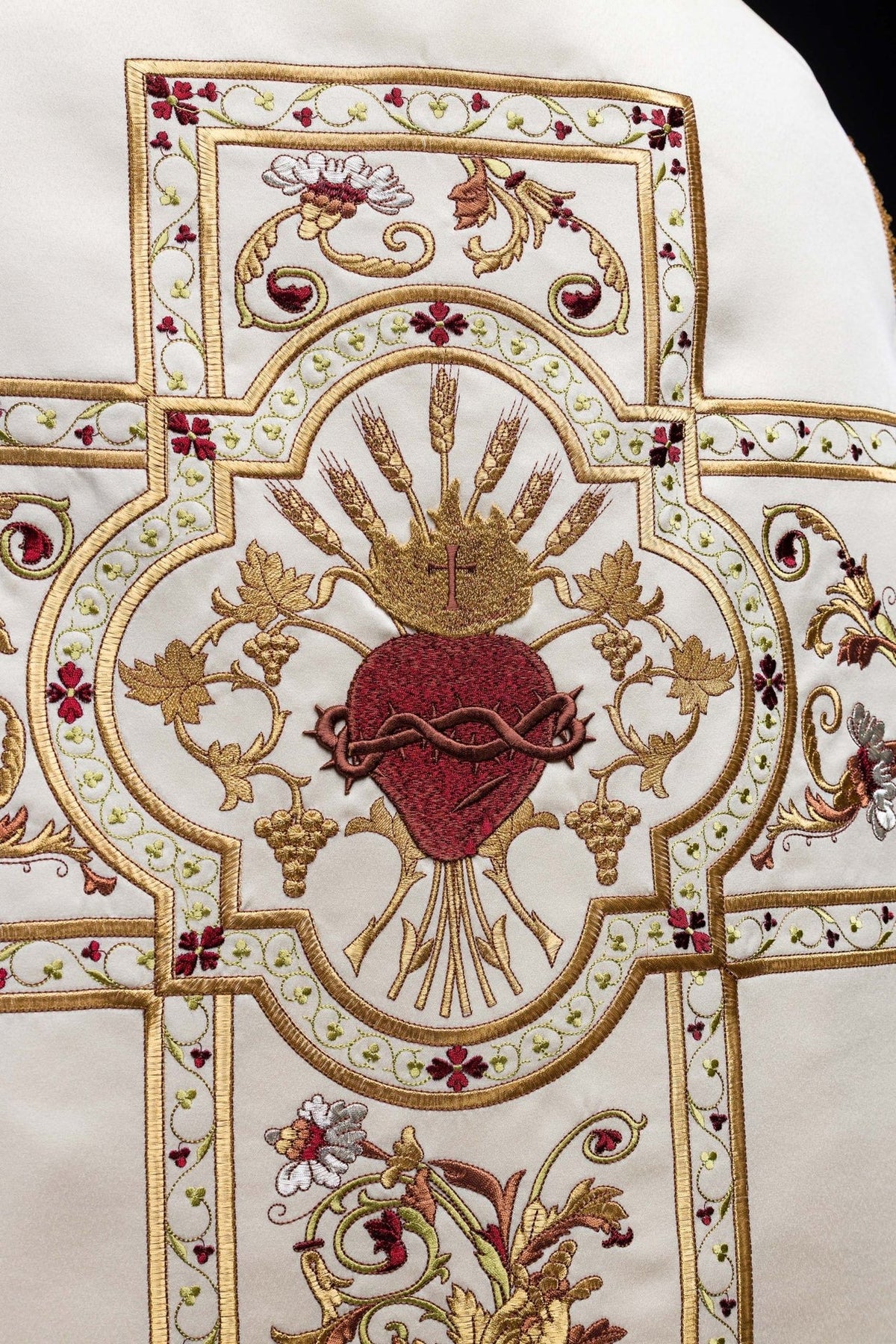 Roman chasuble close-up showing embroidered Sacred Heart of Jesus and gold motifs